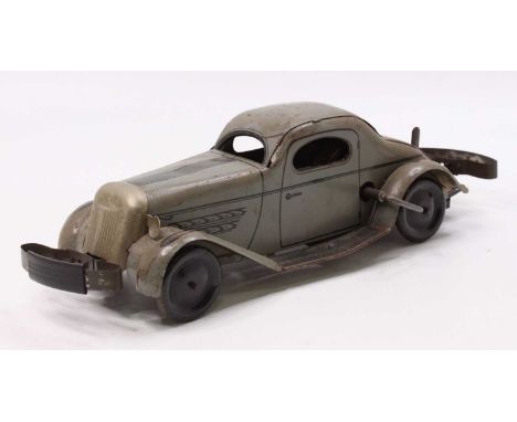 Marx, tinplate and clockwork model of a grey bump and go car, with grey body lined with black decoration, blue wheels and bum