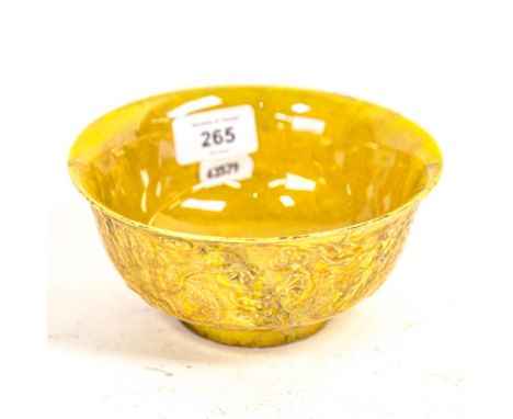 A Chinese yellow glazed ceramic bowl, with embossed dragon decoration, 6 character mark, 15cm 