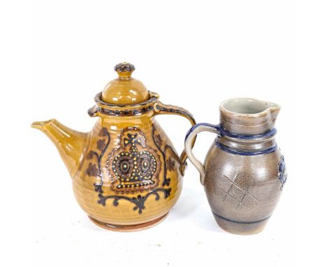 A Continental glazed pottery teapot with crown design, height 26cm, and a stoneware jug with bird and foliate decoration 