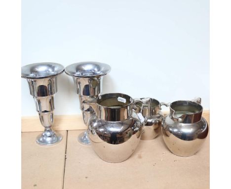 A graduated set of silver lustre jugs, and a pair of metal vases, height 22cm 
