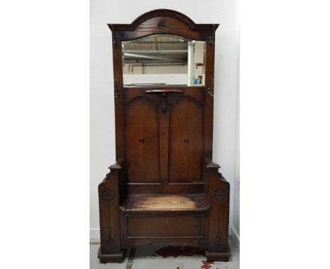 OAK HALL STANDwith an arched top and carved shell motif above a shaped bevelled mirror with a central shelf below, with four 