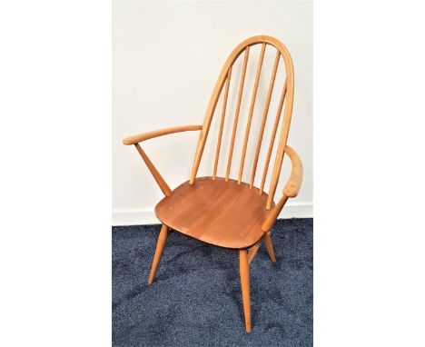 ERCOL QUAKER CARVER CHAIRwith an arched beech stick back above an elm seat, standing on turned supports united by a stretcher