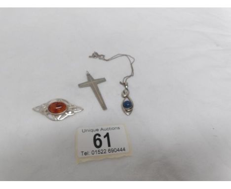A silver pendant on chain, a silver cross and a silver brooch set amber