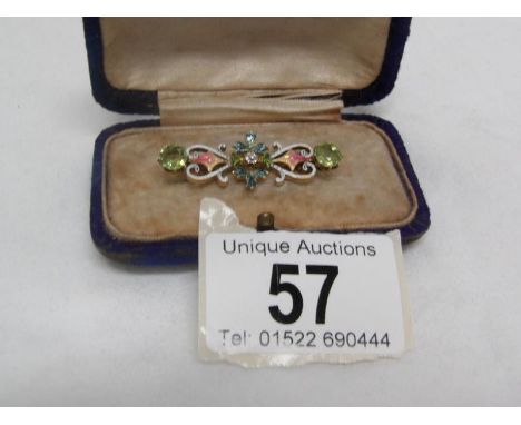 A yellow metal and enamel brooch set central diamond and 2 peridot