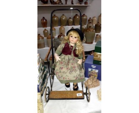 A vintage dolls pushchair and a porcelain doll