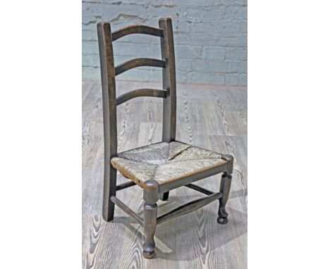 A child's rush seated ladder back chair, circa 1870, height 64cm.
