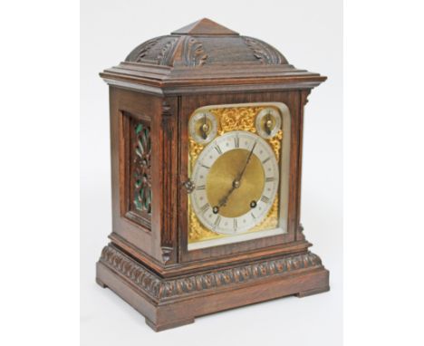 A carved oak mantel clock with brass and steel dial, the movement stamped 'W&H', circa 1900, height 35cm.