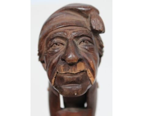 A Black Forest lever action novelty nut cracker formed as a man wearing a cloth hat, circa 1900, length 19cm. Condition - los
