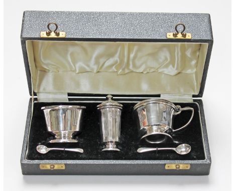 A cased Art Deco style hallmarked silver cruet set (one spoon EPNS and matched).