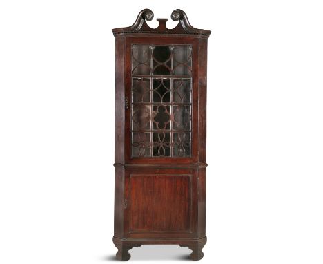 A GEORGE III MAHOGANY CORNER DISPLAY CABINET,  with broken neck pediment and rosette terminals, the moulded dentil cornice ab