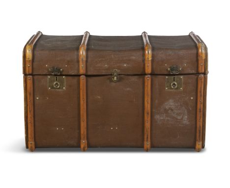 A EDWARDIAN METAL AND TIMBER BOUND TRAVELLING TRUNK, the sides with stitched leather finish and leather carrying handles, wit