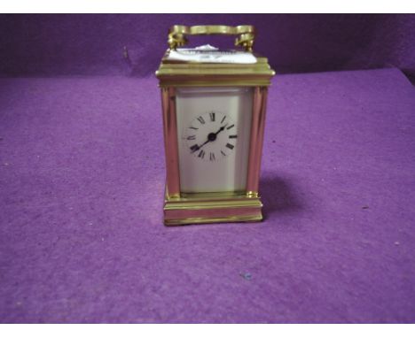 A miniature French brass cased carriage clock having visible escape and bevel edged panels stamped ACG