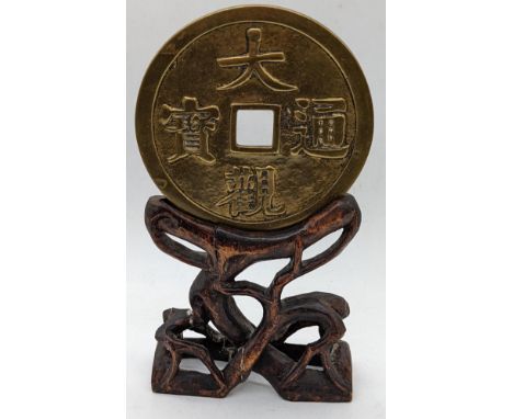 A large Chinese coin on hardwood stand, total item height 20.5cm