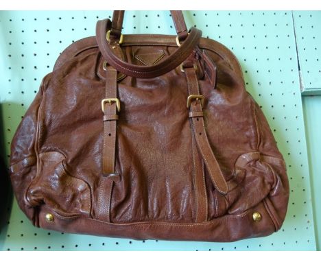 A ladies Prada brown soft leather handbag, having leather lined interior with twin pockets, single zip closure, adjustable si