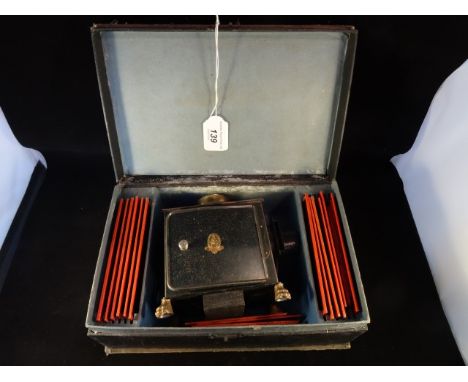 A late Victorian/early Edwardian cased child's magic lantern, to include a quantity of slides, the sets contained in original