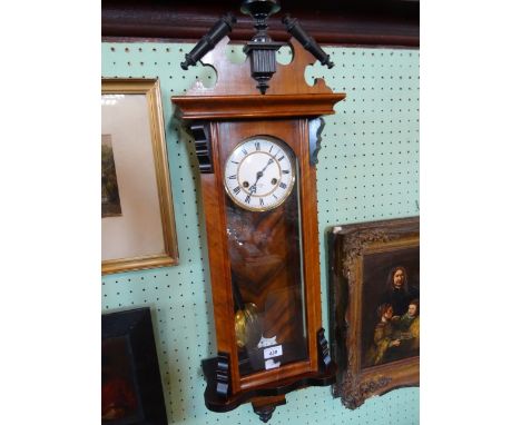 A 20th century eight day Vienna wall clock with ebonised decoration, the enamel face with Roman numerals, 95cm.