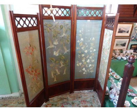 A late 19th/early 20th century mahogany four panel draught screen, having pierced inlaid decoration over embroidered tapestry