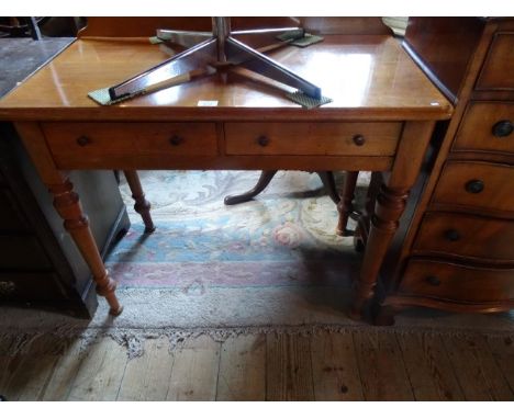 An Edwardian light oak side table, having twin drawers on four turned supports, 91cm wide.