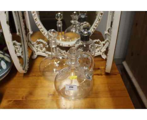 A glass decanter and stopper with silver collar; together with two other glass decanters
