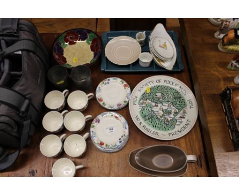 A Poole Pottery charger, "The Society of Poole men", together with Poole Pottery cups and saucers, a gravy boat on stand, a R