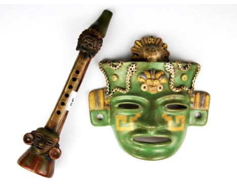 Two South American glazed pottery items in the style of the Inca mask and flute, flute length 34cm.