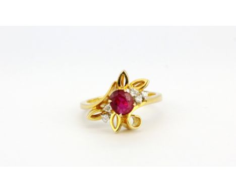 A 14ct yellow gold (stamped 585) ring set with an oval cut ruby and brilliant cut diamonds, (J.5).