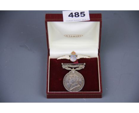 An enamelled RAF pin and a Territorial Army medal.