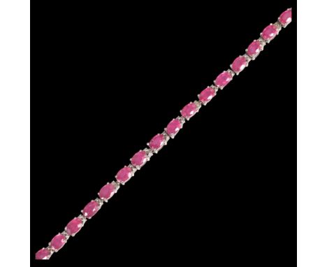 A sterling silver ruby tennis line bracelet, claw set with oval mixed-cut rubies, 20cm, 12.3g . Condition Report:No damage or