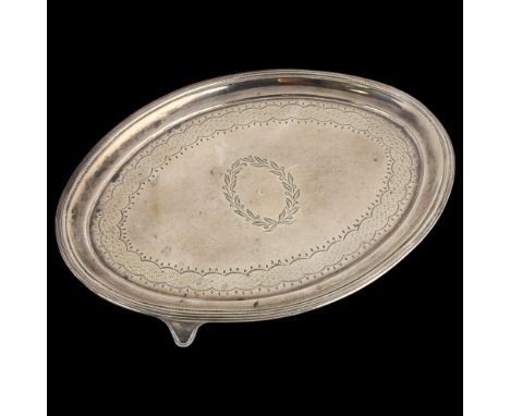 A George III silver teapot stand, John Emes, London 1818, oval form, with bright-cut engraved decoration, raised on 4 feet, 1