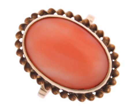 A 9ct gold coral dress ring, rub over set with oval cabochon coral within rope twist surround, setting height 20.4mm, size M,