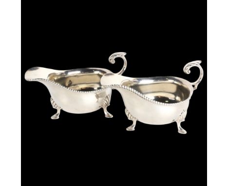 A pair of Edwardian silver sauce boats, Harrison Brothers & Howson, Sheffield 1904, bulbous form, with gadrooned rims, scroll