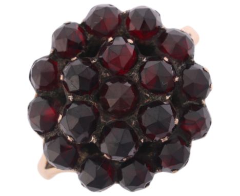 An Antique Victorian Bohemian garnet cluster ring, set with rose-cut garnets with closed-back setting, unmarked mount tests a