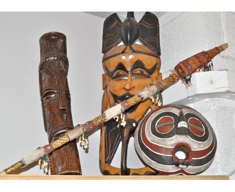 Tribal Art - a carved African wall mask inlaid with ivory and mother of pearl; another, smaller; a trunk mask; a spear (4)