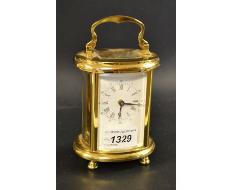A Woodford carriage clock, white dial, Roman numerals, minute track, brass effect oval case, bun feet