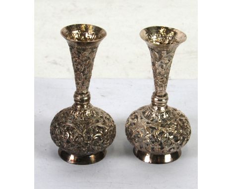 PAIR OF INDIAN SILVER COLOURED METAL SMALL VASES, globe and shaft shaped with trumpet shaped neck, chased and repoussé with f