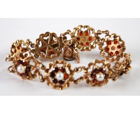 9ct GOLD BRACELET with eight floral links each set with a centre pearl and surround of six garnets, London 1969 and having a 