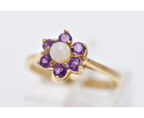 A 9CT GOLD OPAL AND AMETHYST CLUSTER RING, designed with a central opal cabochon (one claw has moved away from the stone), wi