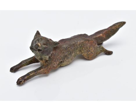 A COLD PAINTED BRONZE FOX, in a running position holding something in its mouth, approximate length 98.6mm, two holes to the 