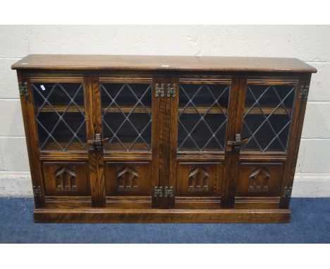 AN OAK LEAD GLAZED FOUR DOOR BOOOKCASE, width 141cm x depth 29cm x height 87cm (missing one shelf hook)