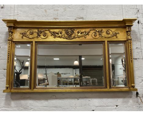 A gilt composition framed over mantel mirror of Neoclassical design, the frieze with scrolling foliate and mythical winged be