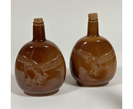 A pair of brown ceramic Carlton Ware for Beneagles scotch whisky decanters embossed with an Osprey to the front. (marked vers