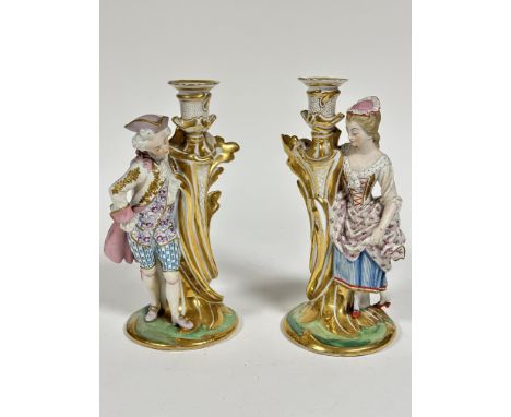 A pair of 19thc Continental porcelain figure candlesticks of a Lady and Gentleman in 18thc style dress and a Gentleman, both 
