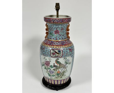 A modern Chinese famille rose style baluster vase lamp with animal figure handles to sides, decorated with pink and yellow fl