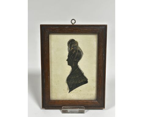 A Regency style silhouette portrait miniature highlighted with gilt to lace and hair, in oak glazed frame in coloured paper, 
