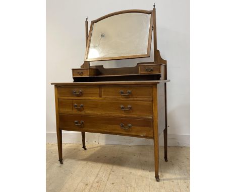 An Edwardian inlaid mahogany dressing chest, the top with swing mirror over two trinket drawers, the base with two short and 
