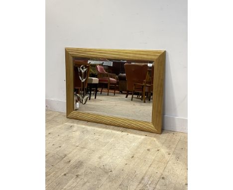 A gilt framed wall mirror, the bevelled plate engraved with a tulip, 76cm x 109cm
