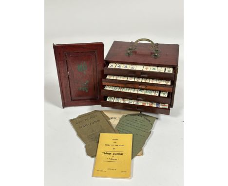 An early 20th century red lacquer box, containing a Mah-Jong bone carved set, made by The Chun Wah Trading Co, including tile