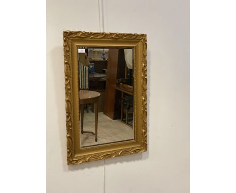A gilt painted composition framed wall mirror, with bevelled glass plate, 77cm x 55cm