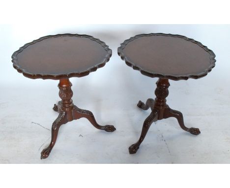 A pair of mahogany tripod tables, with pie crust edge to the circular top, raised on turned carved columns and three out swep
