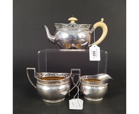 A silver three piece tea set with pierced gallery detail, gilt interior (ivory handle on teapot), hallmarked London 1901 by E